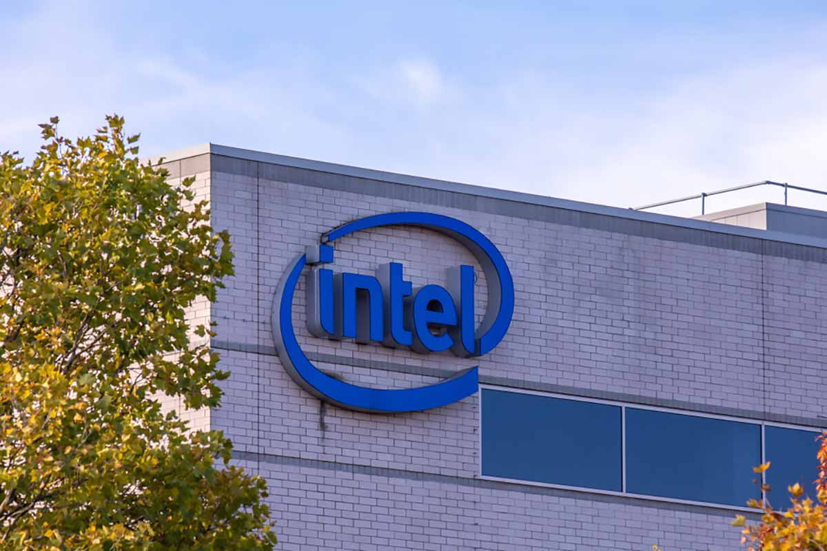 Intel sign on company building with blue sky and trees.