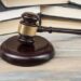 Court gavel on table with books.