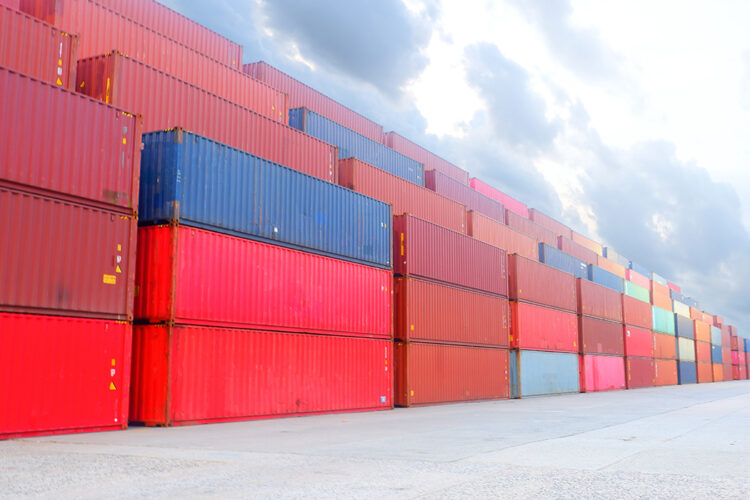 Shipping containers stacked in a logistic yard.