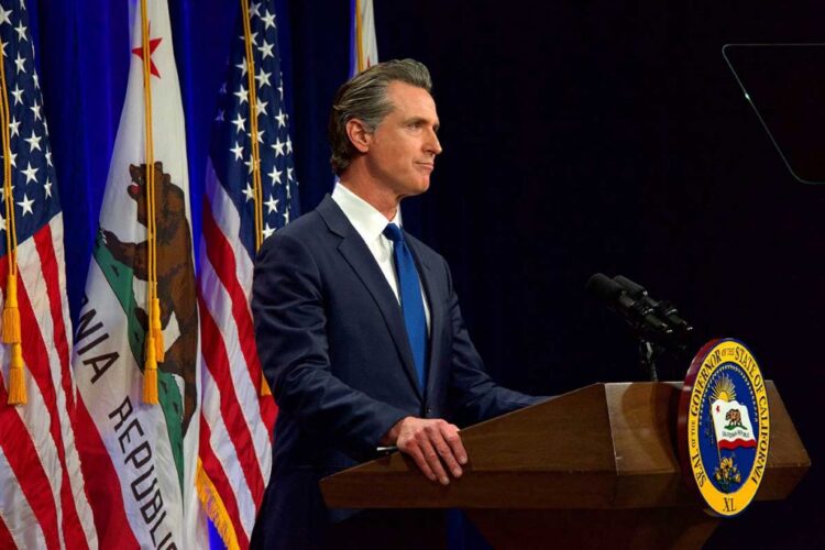 California Governor Gavin Newsom speaking at podium.