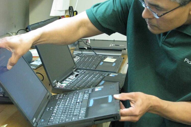 PlanITROI employee processing a device.