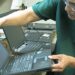PlanITROI employee processing a device.