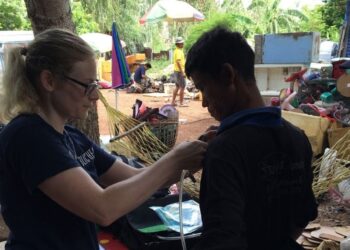 Researcher attaches monitoring device to e-scrap worker.