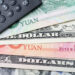 U.S. and Chinese currency with a calculator.