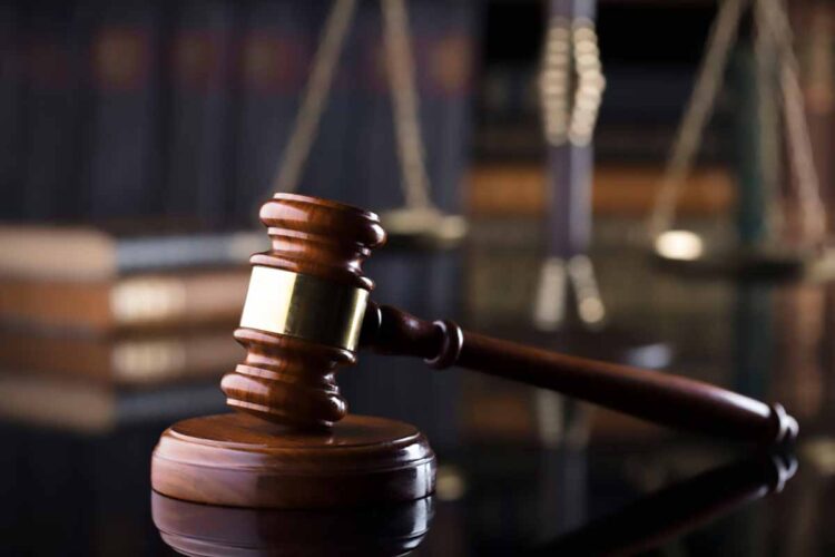 Gavel on a desk with library in background.