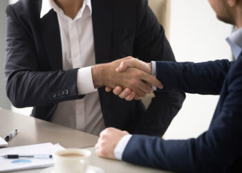 Two businessmen shake hands.
