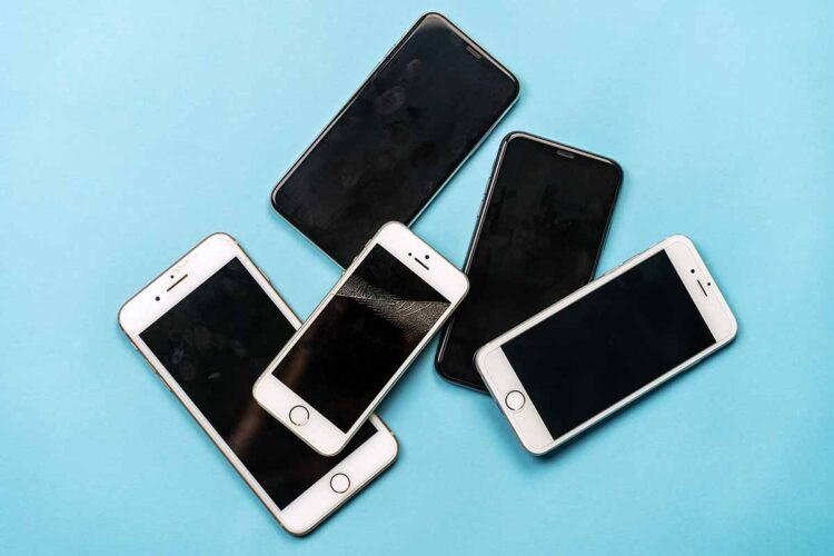 Used cell phones arranged on a blue background.