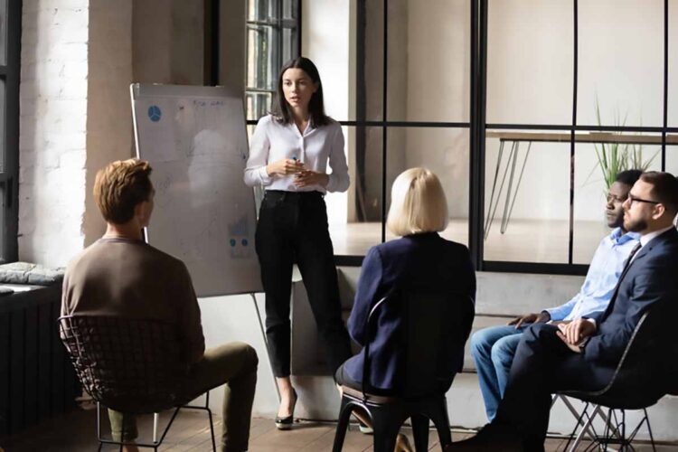 Business presentation by women in front of group.